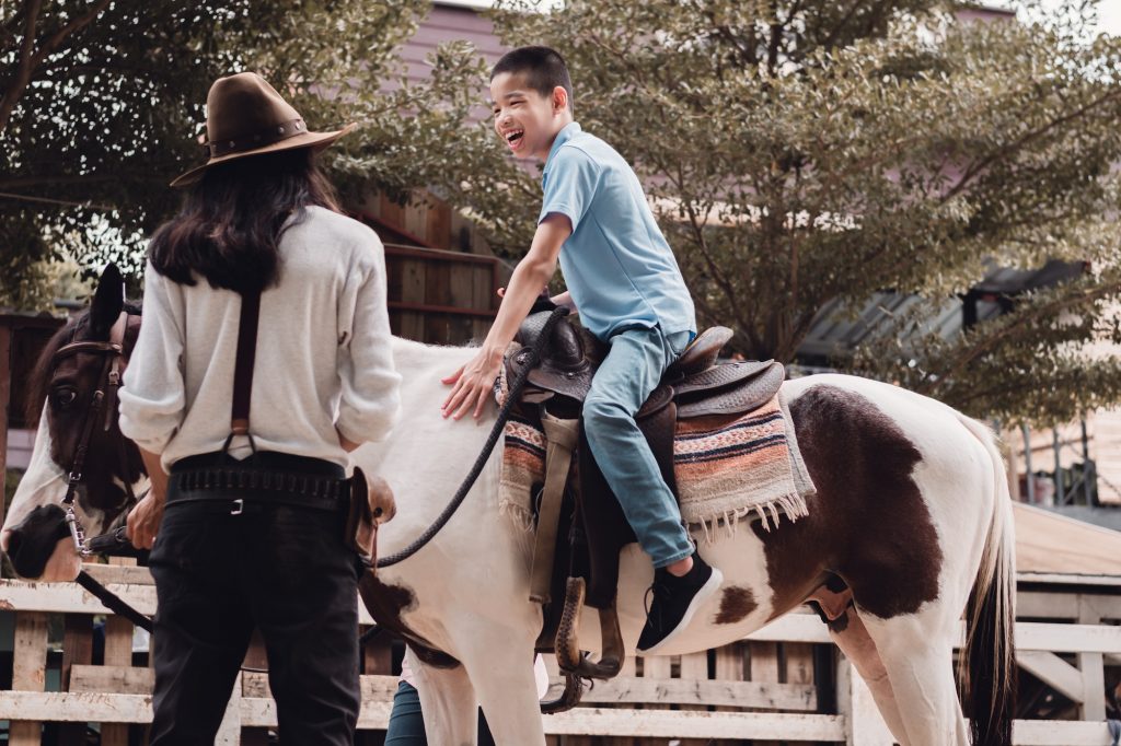 A child with special needs is riding with a close supervision teacher